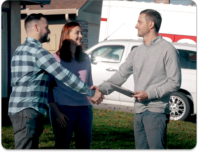 Moving consultant greeting homeowners with a handshake during an onsite survey, highlighting trust-building with the Movegistics Survey App